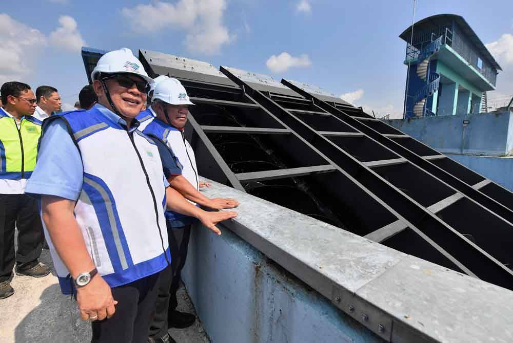 Mohamad (kanan) dan Izham (kiri) melihat rumah pam selepas Majlis Perasmian Rumah Pam Taman Sri Muda Seksyen 25, pada Isnin. Foto Bernama