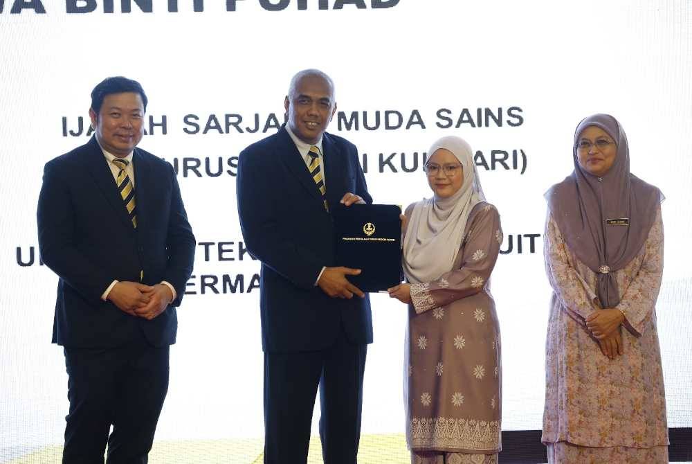 Khairudin (dua dari kiri) menyampaikan sijil kepada pelajar cemerlang ketika menyempurnakan Sesi Penyampaian Sijil Anugerah Cemerlang dan Hadiah Pemenang JomPay & Menang Pinjaman Pengajian Tinggi Negeri Perak di Bangunan Perak Darul Ridzuan di sini pada Isnin.
