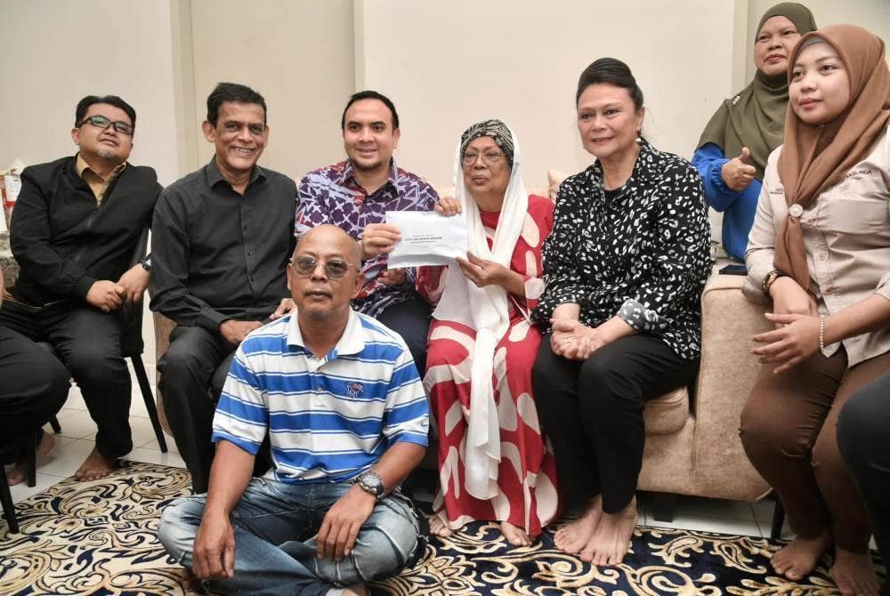 Ahmad Farhan (tiga dari kiri) menyampaikan sumbangan kepada Safiah (empat dari kiri) pada Isnin. Foto Facebook Anwar Ibrahim