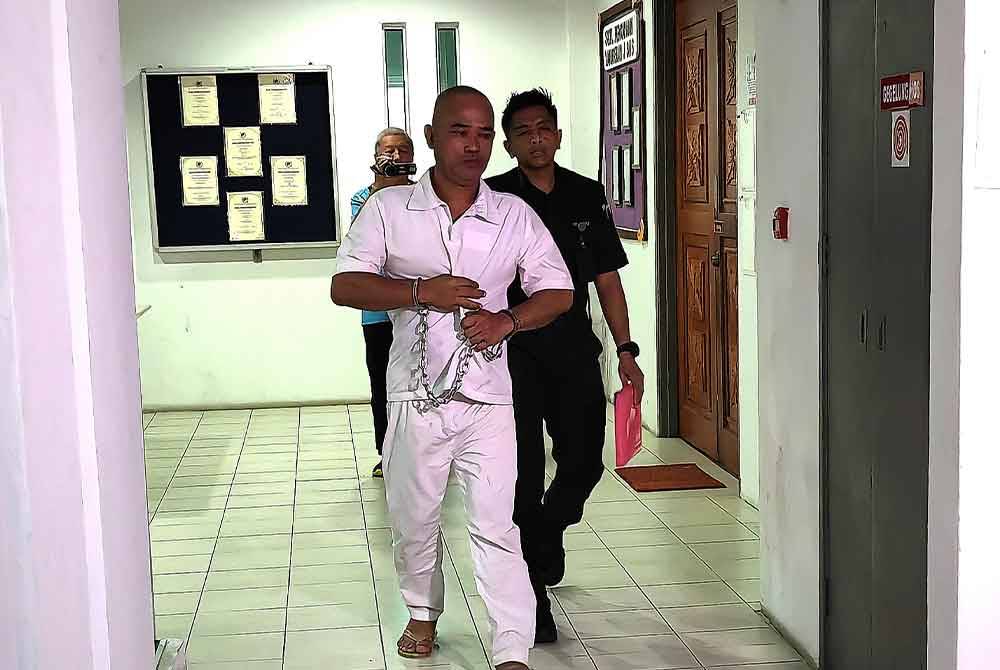 Norasid diiringi pegawai penjara ketika hadir ke mahkamah