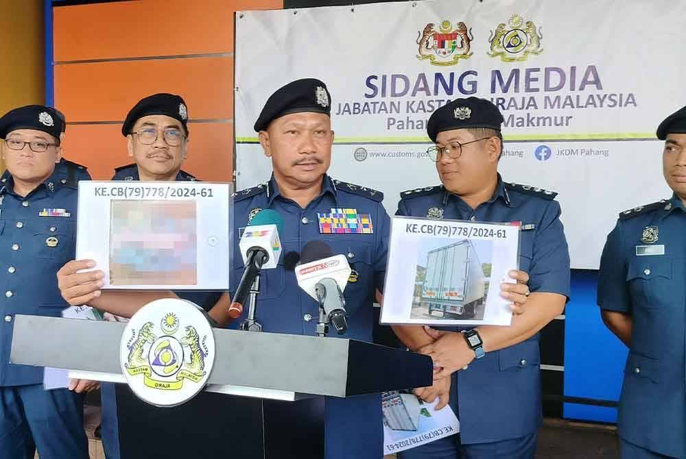 Mohd Asri menunjukkan gambar lori membawa daging khinzir sejuk beku yang dirampas di KM131, Laluan Jeli- Gerik, Gerik, Perak,17 Julai lalu.