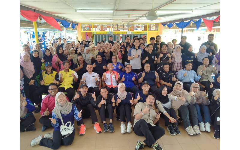 Che Mohd Zulkifli (duduk di kerusi, empat dari kanan) bersama Khairudin (duduk di kerusi, tengah) bersama pelajar dan keluarga angkat masing-masing.