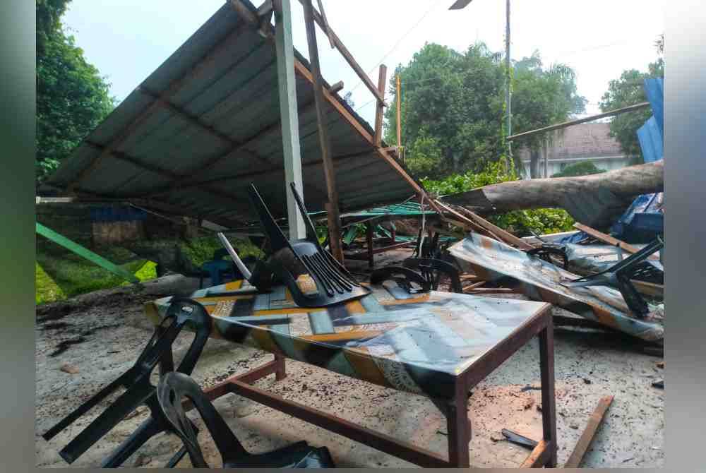 Keadaan kedai makan yang diusahakan Haliza dan suami musnah dihempap sebatang pokok.