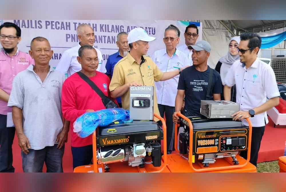 Muhammad Faiz (tiga dari kiri) beramah mesra bersama sebahagian nelayan penerima Bantuan Titik Sentuhan Kawasan Kuantan dan Pekan Tahun 2024 sempena Majlis Pecah Tanah Kilang Air Batu PNK Kuantan di Kompleks LKIM, Kemunting pada Rabu.