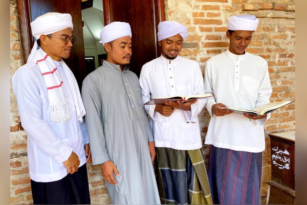 Pelajar-pelajar pondok di Pattani, Thailand melihat naskah al-Quran yang disumbangkan kepada mereka.