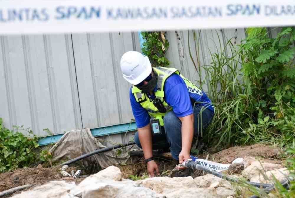 Anggota penguatkuasa SPAN melakukan kerja-kerja pemotongan pada saluran air yang disambung secara tidak sah di sebuah tapak pembinaan projek landasan kereta api di Taman Melati, Gombak. Foto Bernama