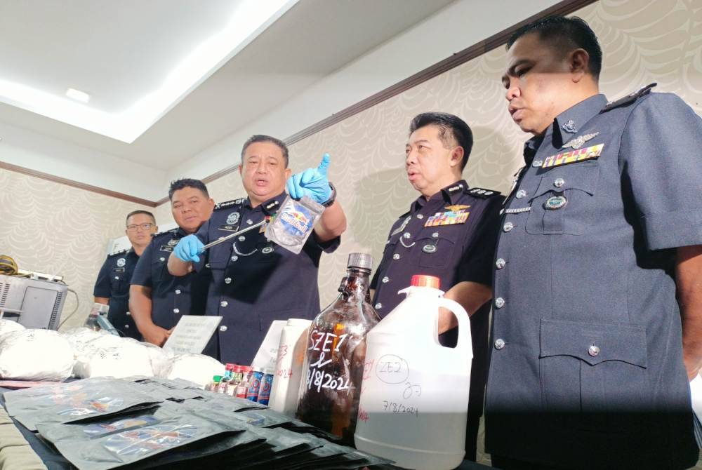 Azizi menunjukkan bungkusan serbuk jus dicampur bahan mengandungi dadah yang berjaya dirampas dalam serbuan di sebuah rumah di Buntong pada Rabu.