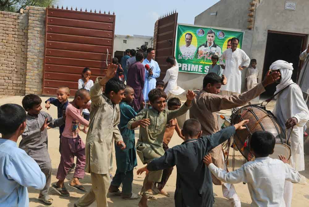 Kanak-kanak meraikan kejayaan Arshad Nadeem meraih emas rejam lembing lelaki di kediaman atlet tersebut di Mian Channu. - AFP