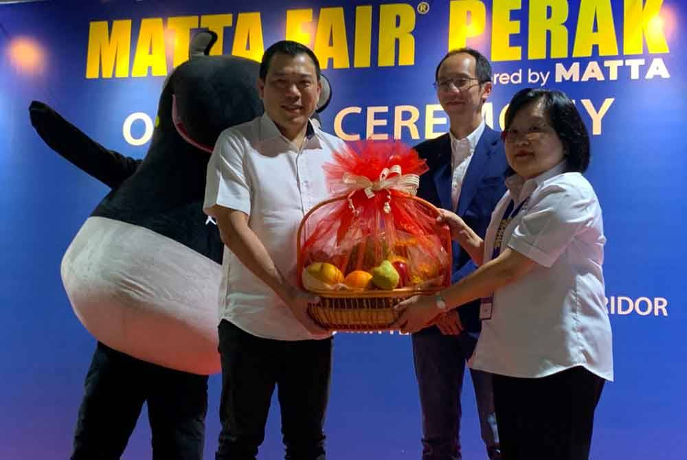 Sze Yee menerima cenderahati daripada Wendy (kanan) selepas merasmikan MATTA Fair Perak ke-33 di Pusat Konvensyen Ipoh di sini pada Sabtu.