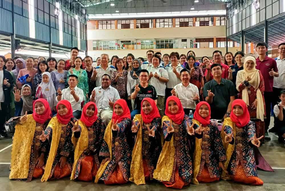 Kah Woh (duduk tengah) bersama barisan pelajar dan komuniti kampung baru yang menjayakan Program Semarak Bahasa Kebangsaan Kampung Baru Pokok Assam di Sekolah Jenis Kebangsaan Cina (SJKC) Pokok Assam di Taiping pada Ahad.