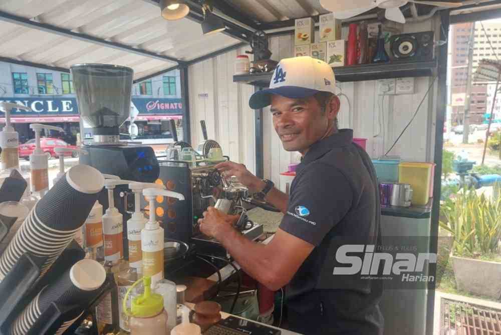 Mohd Zamri menunjukkan cara penghasilan minuman kopi.