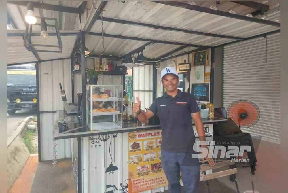 Mohd Zamri bergambar di hadapan perniagaan kopi berkonsepkan kios miliknya.
