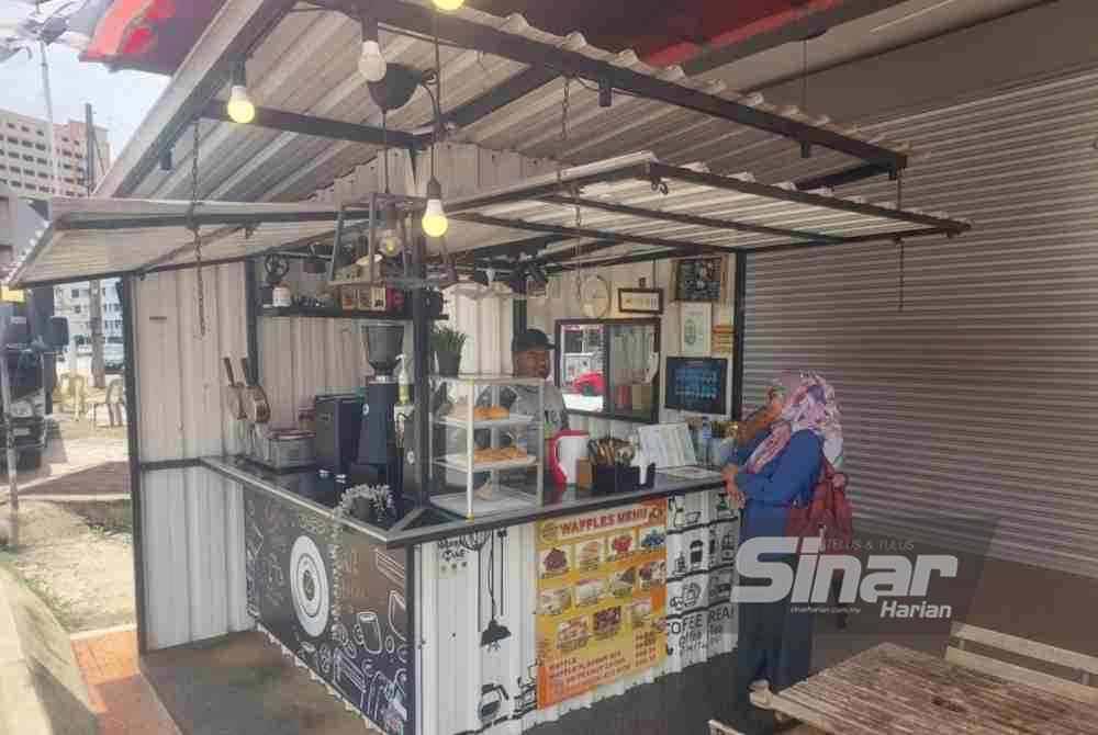 Pekerja di Zs Coffee Shop sedang mengambil tempahan daripada pelanggan.