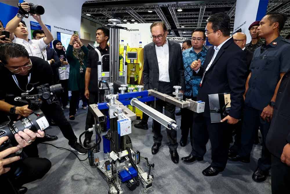 Anwar melawat reruai pameran selepas merasmikan Sidang Kemuncak Tahun Pengkomersialan Malaysia 2024 pada Isnin. Foto Bernama 