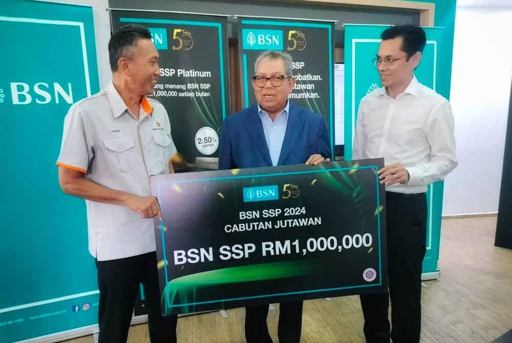 Awang Adek (tengah) beramah mesra bersama Mohd Azhar (kiri) yang memenangi Cabutan Jutawan BSN SSP
di BSN Cawangan Utama Negeri Kedah pada Isnin.