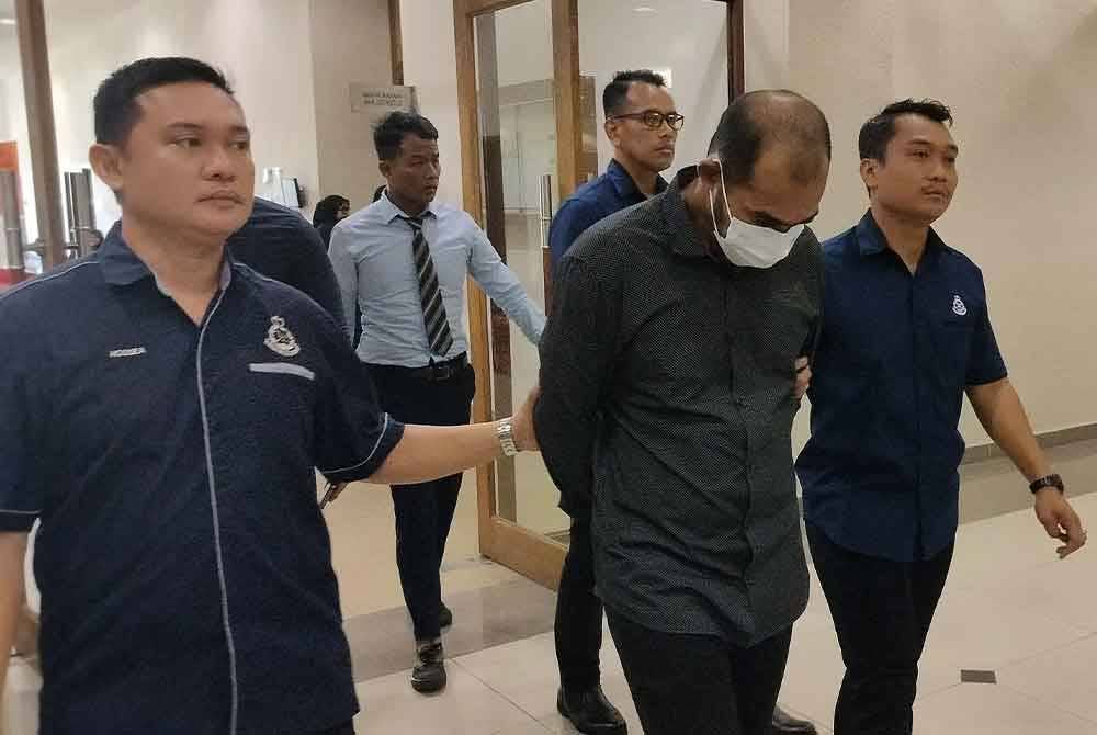 Tertuduh (dua dari kanan) diiringi keluar selepas selesai sebutan kes mengedar 111,663.51 gram kanabis yang dihadapi dalam Mahkamah Majistret di sini pada Selasa.