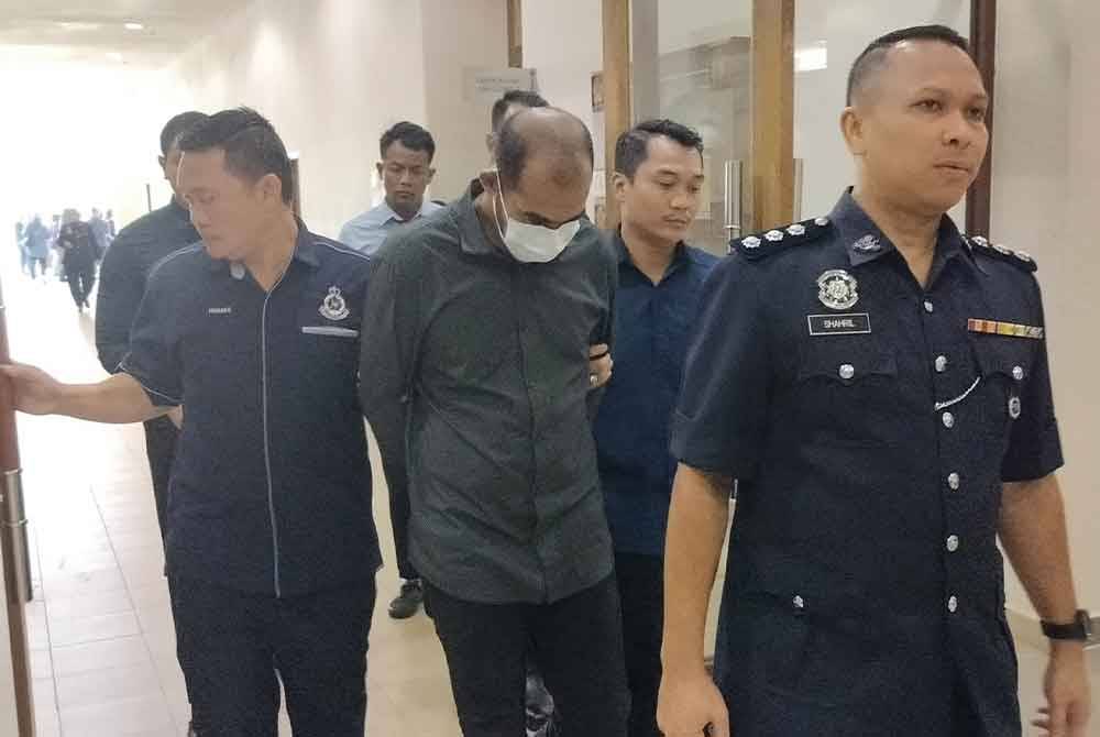 Tertuduh (dua dari kiri) diiringi keluar selepas selesai sebutan kes mengedar 111,663.51 gram kanabis yang dihadapi dalam Mahkamah Majistret di sini pada Selasa.