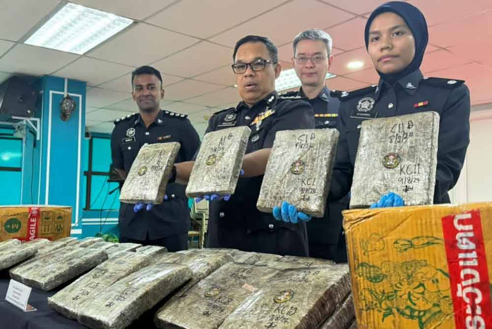 Razlam (dua dari kiri) menunjukkan dadah ganja yang dirampas daripada kedua-dua suspek.