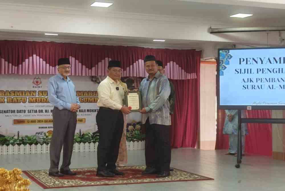 Mohd Na'im (tengah) menyampaikan sijil penghargaan kepada AJK Pembangunan Surau Al-Marjan SMK Batu Muda pada Selasa.