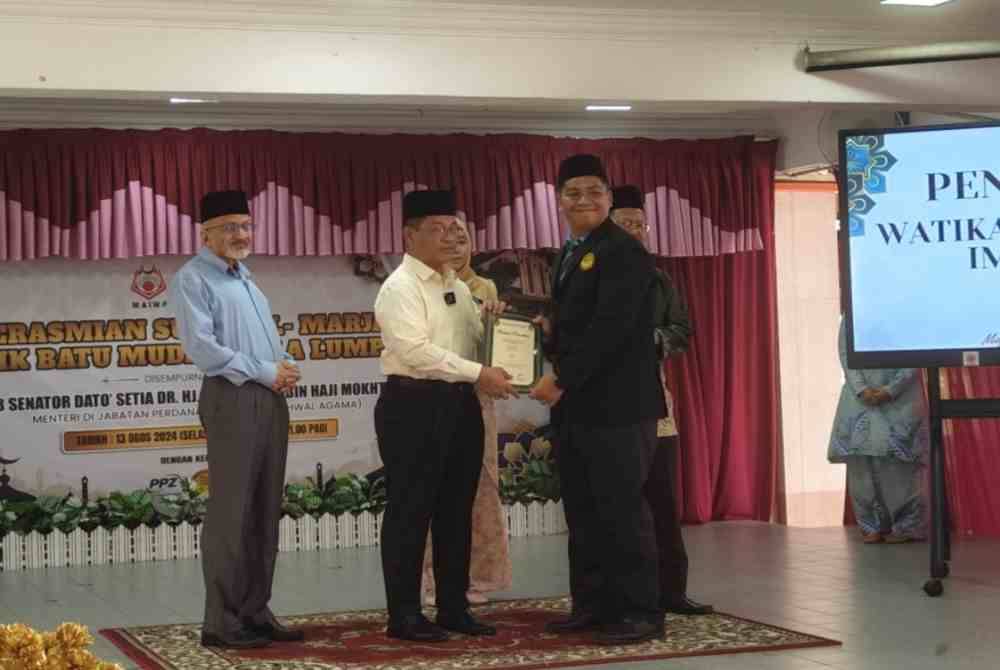 Mohd Na'im (tengah) menyampaikan watikah pelantikan Imam Muda Surau Al-Marjan.