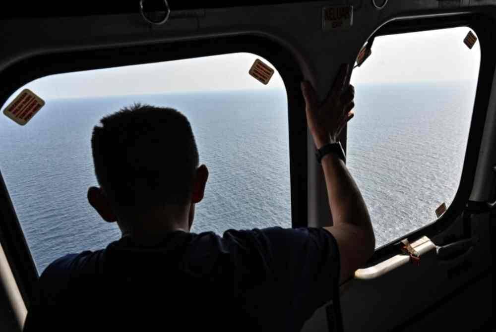 Pasukan anggota Jabatan Bomba dan Penyelamat Malaysia (JBPM) melakukan tinjauan dari udara menggunakan sebuah helikopter bagi operasi Carilamat dua lagi mangsa yang hilang dalam insiden bot karam di perairan Kemaman. Foto Bernama