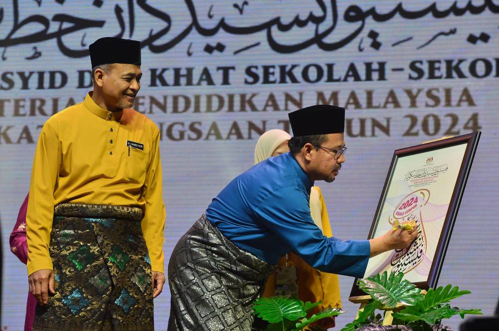 Mohamad Zaki menyempurnakan gimik penutup FNKSS sambil diperhatikan Mohamed Nor Salleh.