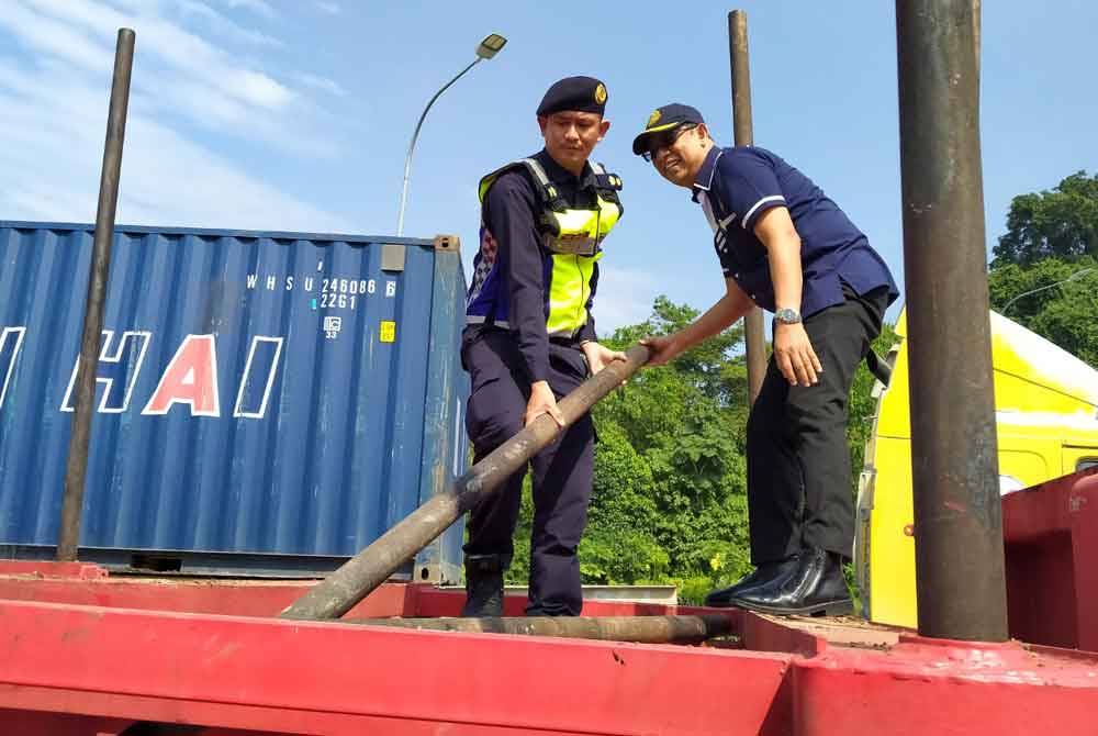 Mohammad Yusoff (kanan) menunjukkan besi penyendal yang tidak diikat dan diletakkan di tempat khas ketika Operasi Khas Kenderaan Perdagangan Bersama Agensi Penguat kuasa dan Konsesi Lebuh raya Tahun 2024 di PLUS berhampiran RTC Perak di sini pada Rabu.