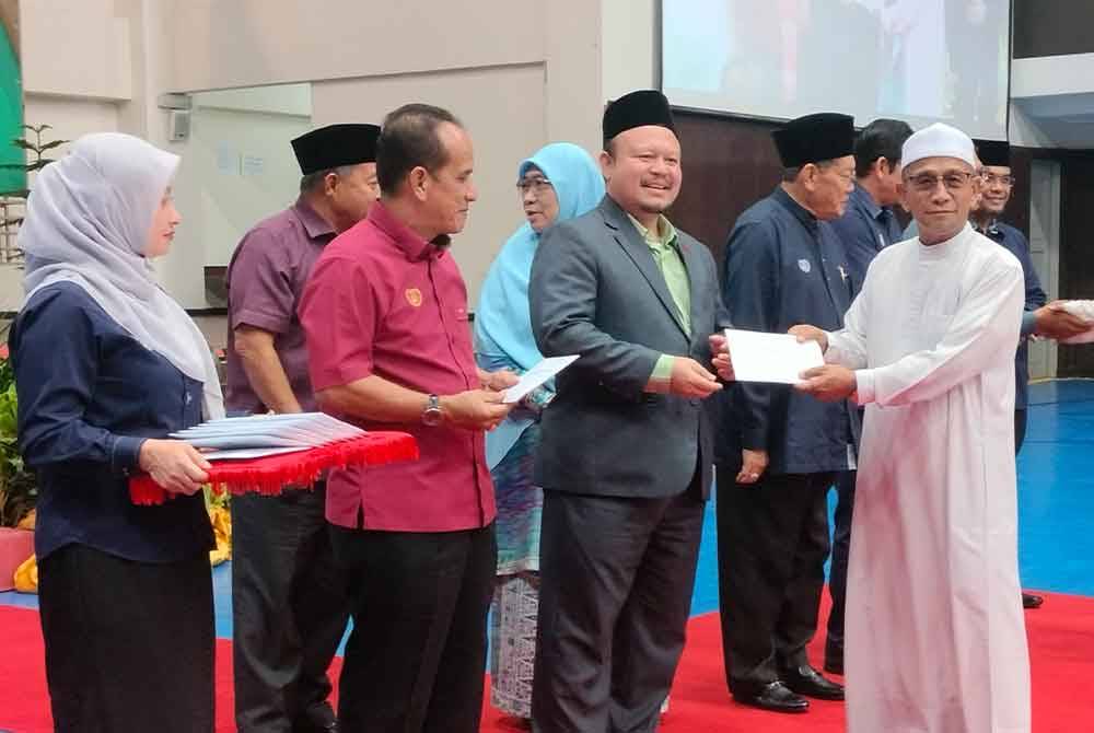 Mohd Azam (dua kanan) menyampaikan bantuan kepada wakil institusi agama sempena Majlis Pemberian Bantuan Operasi dan Agihan Wakalah Zakat pada Rabu.