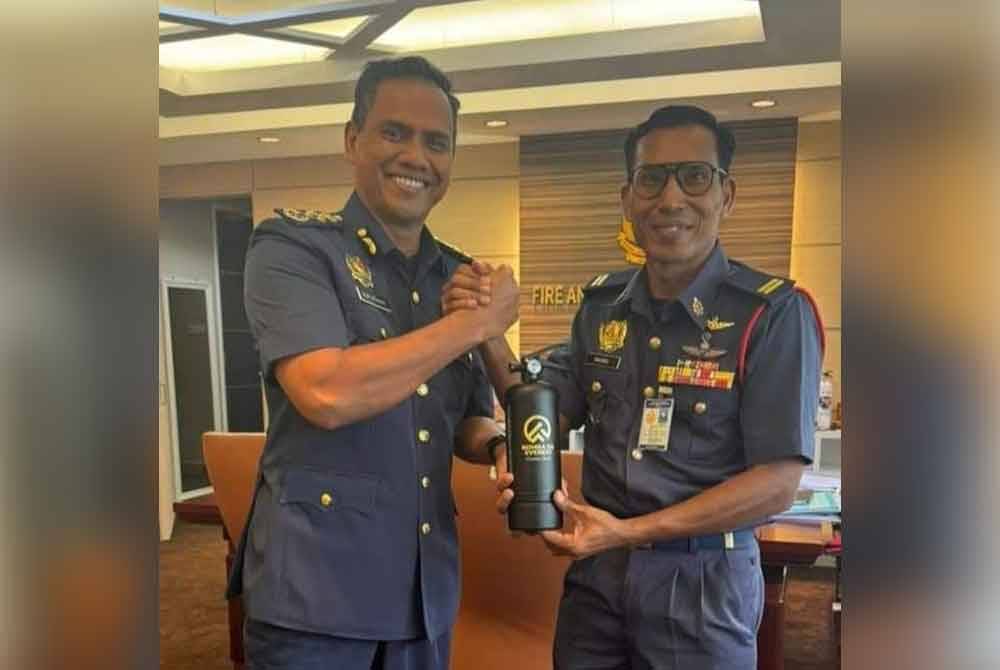 Mohd Fakhrul Munir (kanan) dan Nor Hisham menunjukkan alat pemadam api (edisi khas) yang dijual sempena Projek Pendakian Amal Bomba de Everest ‘Mencari Hati Emas’ 2025.
