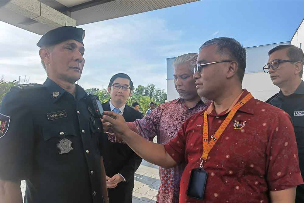 Masri (kanan) melihat kamera badan yang digunakan penguat kuasa MBS.