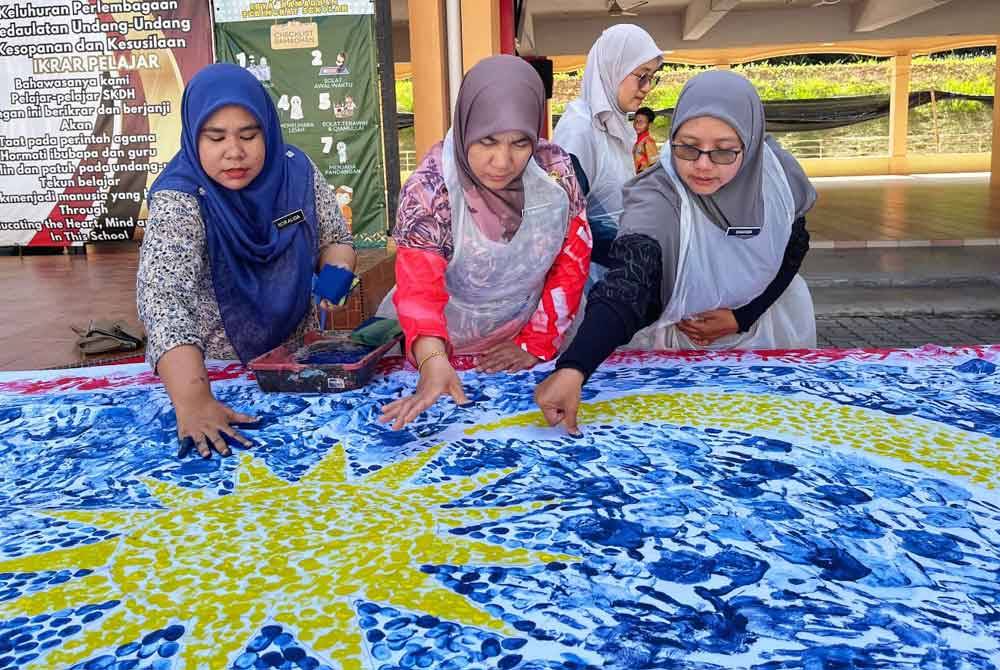 Para guru turut memberi komitmen dalam penghasilan Jalur Gemilang gergasi.