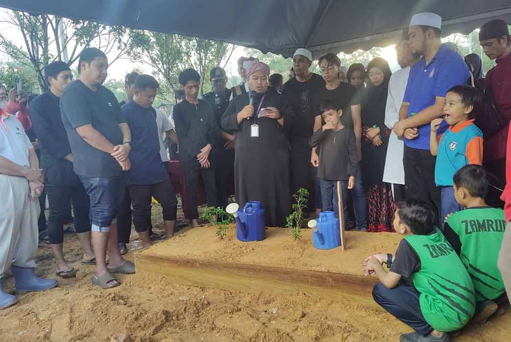Nazir Masjid Puncak Alam, Aiman Wafiy Roslan (depan, kiri) mengetuai bacaan talkin semasa pengebumian Allahyarham Nidza Afham di Tanah Perkuburan Islam Bandar Puncak Alam pada Khamis.