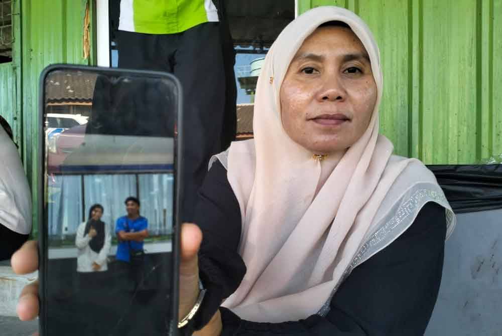 Hanisah menunjukkan gambar Muhammad Aqil bersama kakaknya yang dirakam melalui telefon sebelum kemalangan