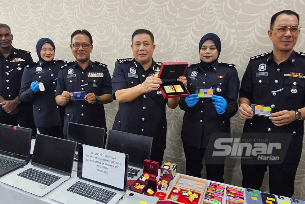 Azizi (tiga dari kanan) menunjukkan barangan kemas yang dirampas dari peti simpan milik suspek yang disyaki hasil penipuan di sebuah rumah sewa yang dijadikan 'calling center' di Taiping.