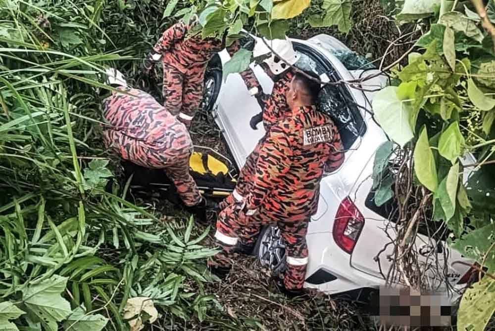 Anggota bomba mengeluarkan mangsa yang tersepit dalam kereta Perodua Axia terbabit. Foto PDRM