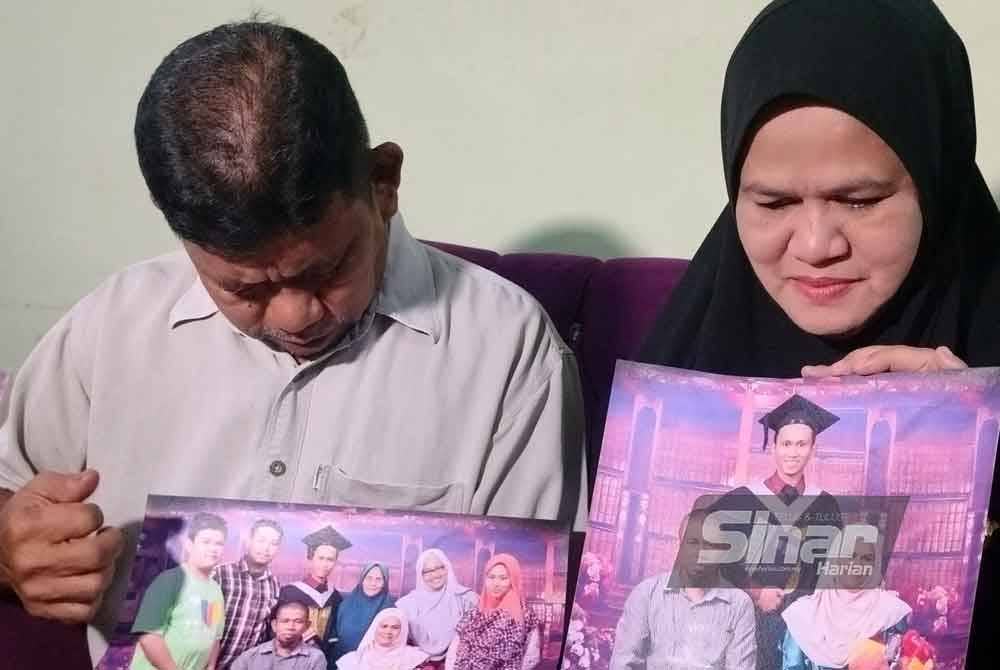 Muhamad Salleh dan Jamilah menunjukkan gambar kenangan arwah Muhamad Hafiz semasa konvokesyen pada 2016.