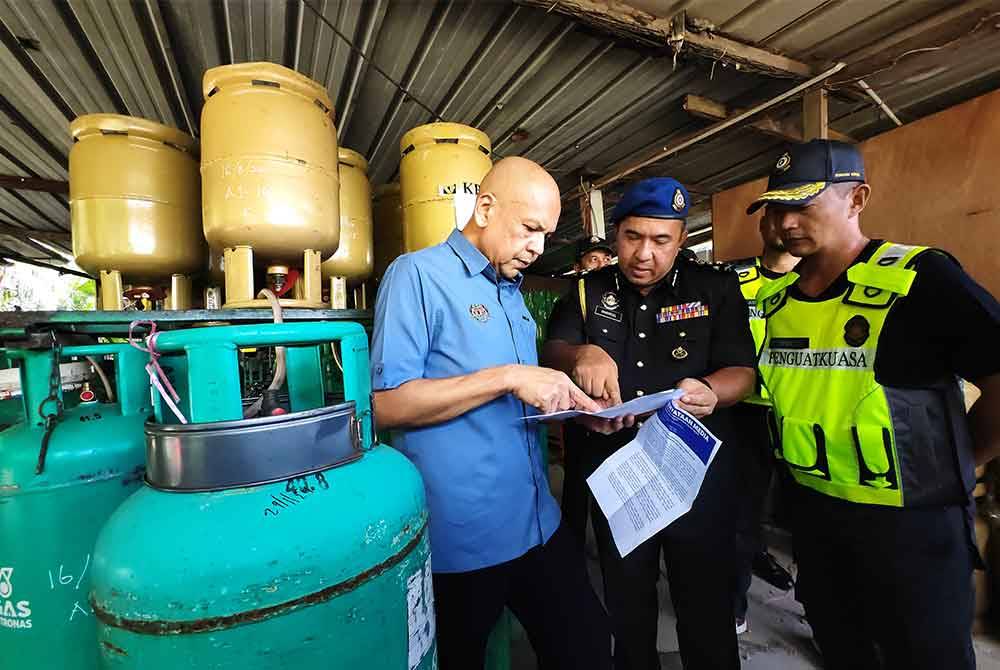 Armizan (kiri) turun padang di premis yang didapati melakukan penyelewengan LPG.