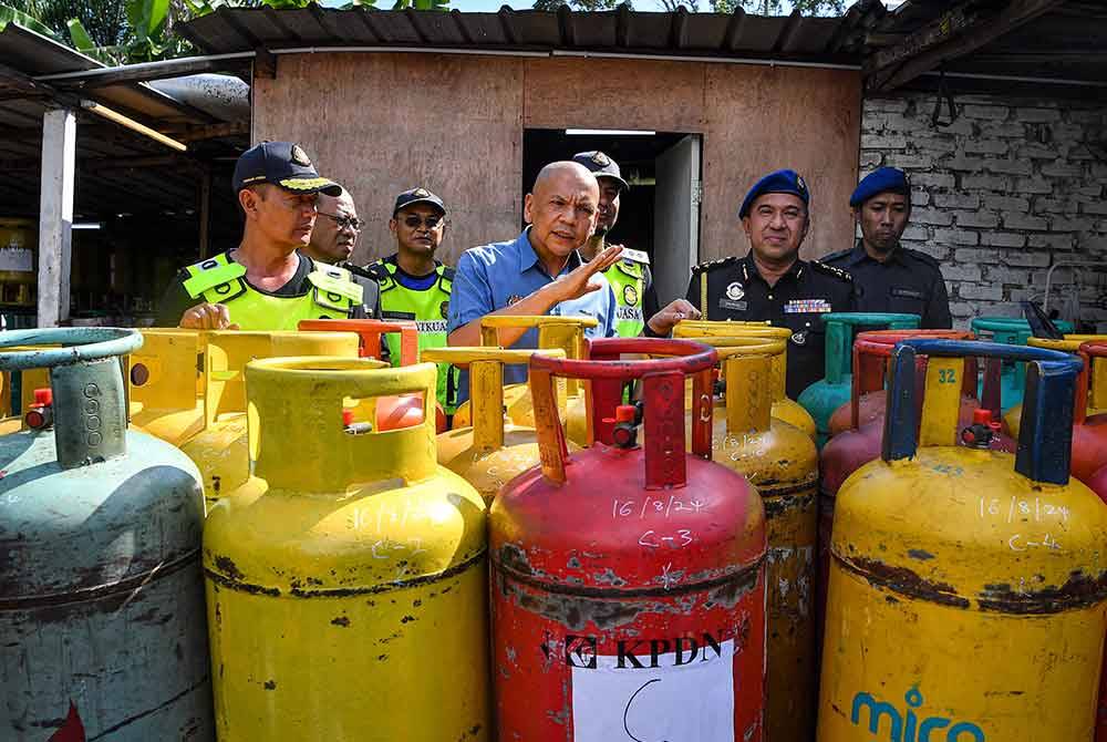Armizan meninjau rampasan unit tong LPG yang diselewengkan dan disimpan dalam stor penyimpanan haram di sebuah premis tanpa nama di Lukut pada Jumaat. Foto Bernama