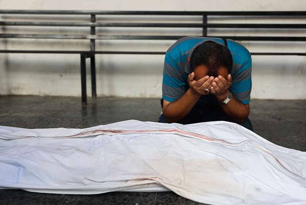 Seorang lelaki meratapi kematian seorang doktor Palestin, Hani al-Jaafarawi yang terkorban semasa klinik mereka di Daraj telah diserang tentera Israel. Foto AFP