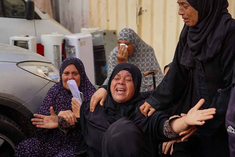Seorang wanita tidak dapat menahan kesedihan meratapi saudaranya yang terkorban dalam serangan udara rejim Zionis di kediaman mereka di Genting Gaza. Foto AFP