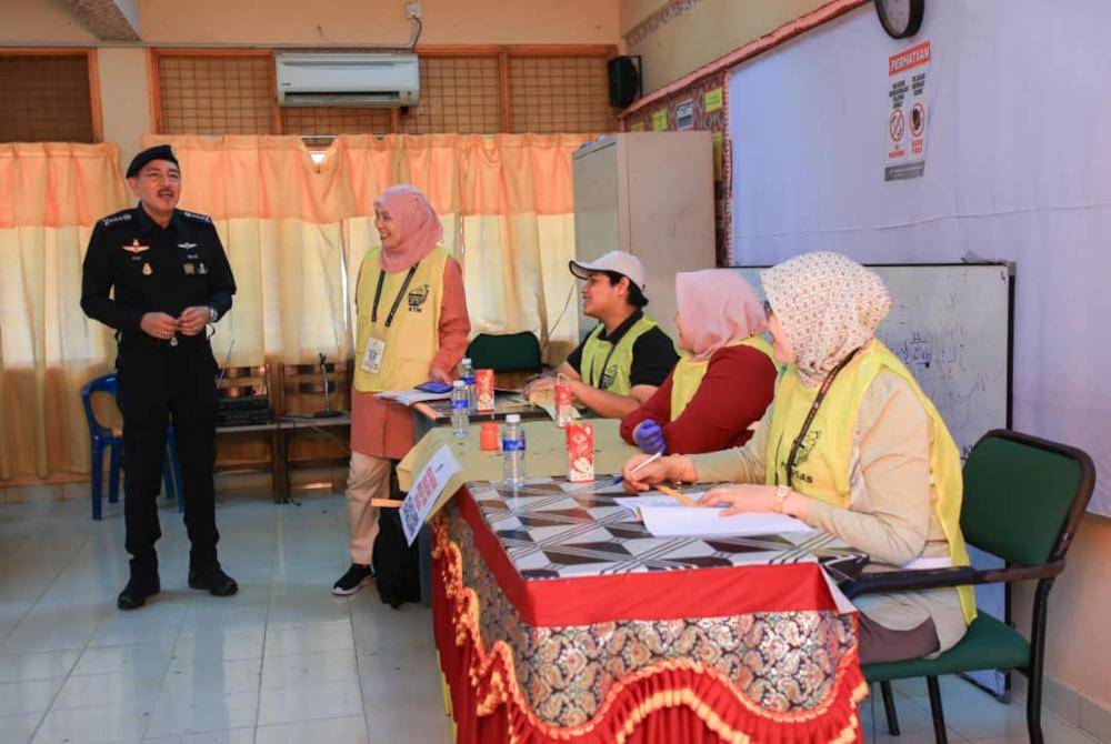Muhamad Zaki meninjau proses pengundian yang berlangsung di PDM SMK Sungai Asap, Gua Musang pada Sabtu.