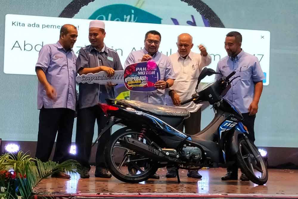 Hadiah utama cabutan bertuah, sebuah motosikal yang dimenangi Kadi Daerah Temerloh, Abdul Aziz Abdul Karim (dua dari kiri) yang disampaikan oleh Amizar (tengah) di Dewan Tun Razak, Temerloh pada Sabtu.