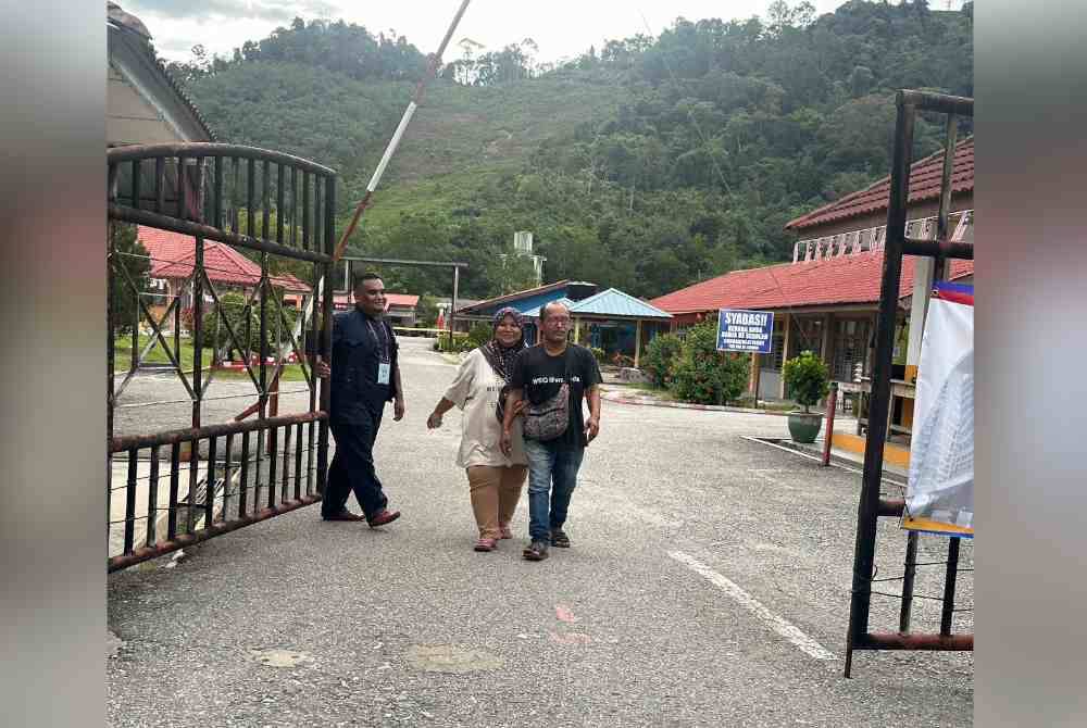 Mohd Amran dan Rashidah keluar daripada pusat mengundi di Sekolah Kebangsaan Renok pada Sabtu.