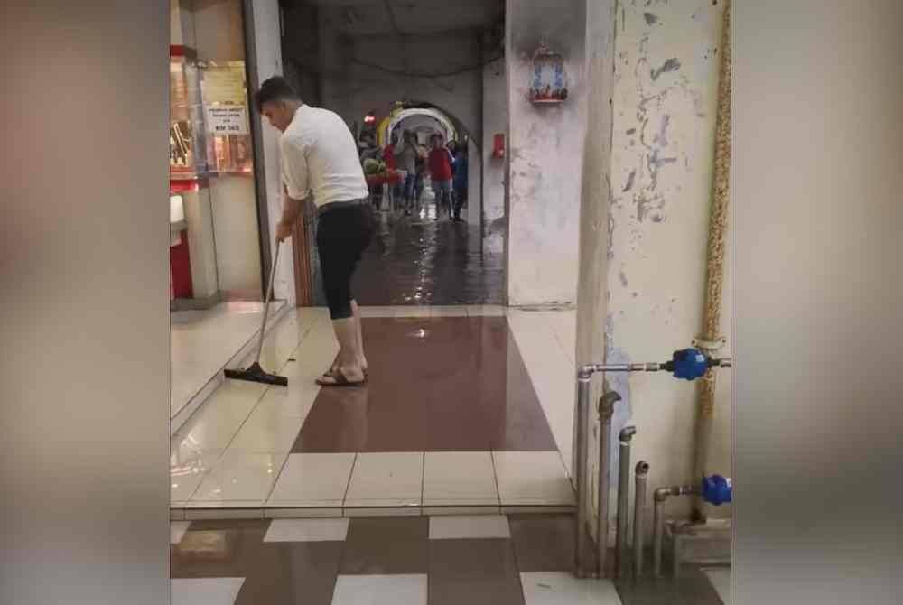 Pekerja membersihkan premis sejurus banjir surut.Foto: Facebook Rawangku.