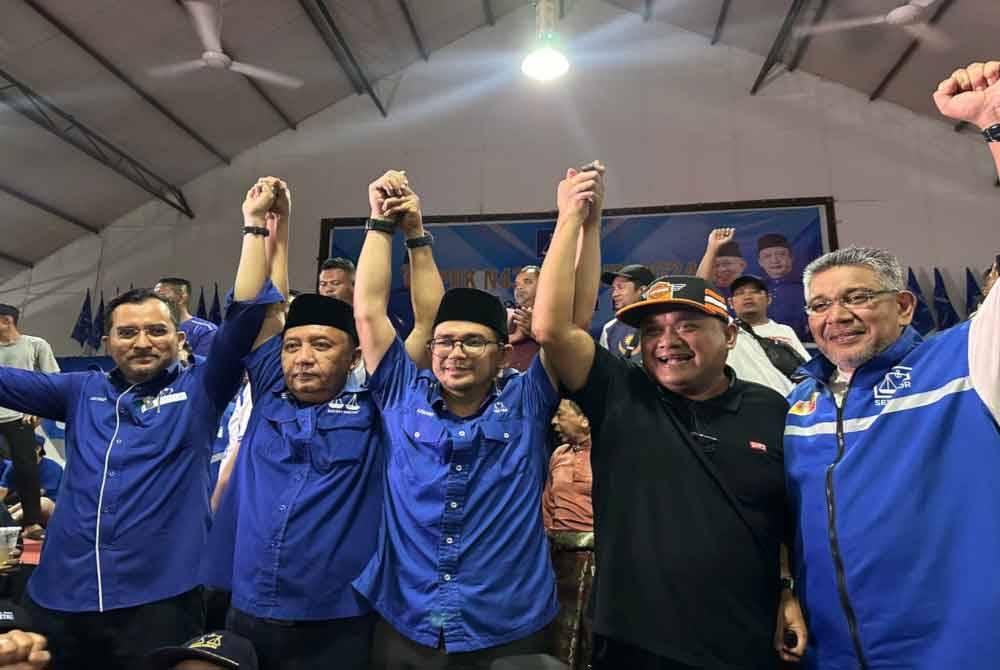 Mohd Asmawi Fikri (tengah) bersama Pengerusi BN Kelantan, Datuk Seri Ahmad Jazlan Yaakub (dua dari kiri) dan Setiausaha Agung UMNO, Datuk Dr Asyraf Wajdi Dusuki (kiri) meraikan kemenangan BN pada PRK Nenggiri hari ini.