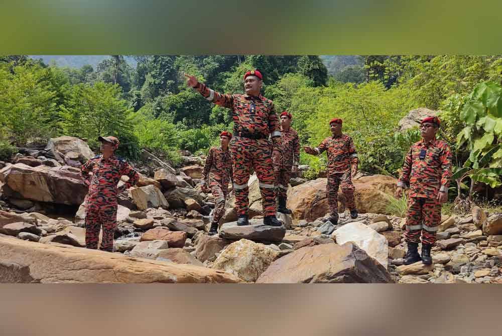 Mohd Jamil (tiga dari kanan) dan anggota Pasukan Khas Must Team Jabatan Bomba dan Penyelamat (JBPM) negeri Kedah menunjukkan lokasi kejadian kepala air di Gunung Jerai yang meragut enam nyawa.