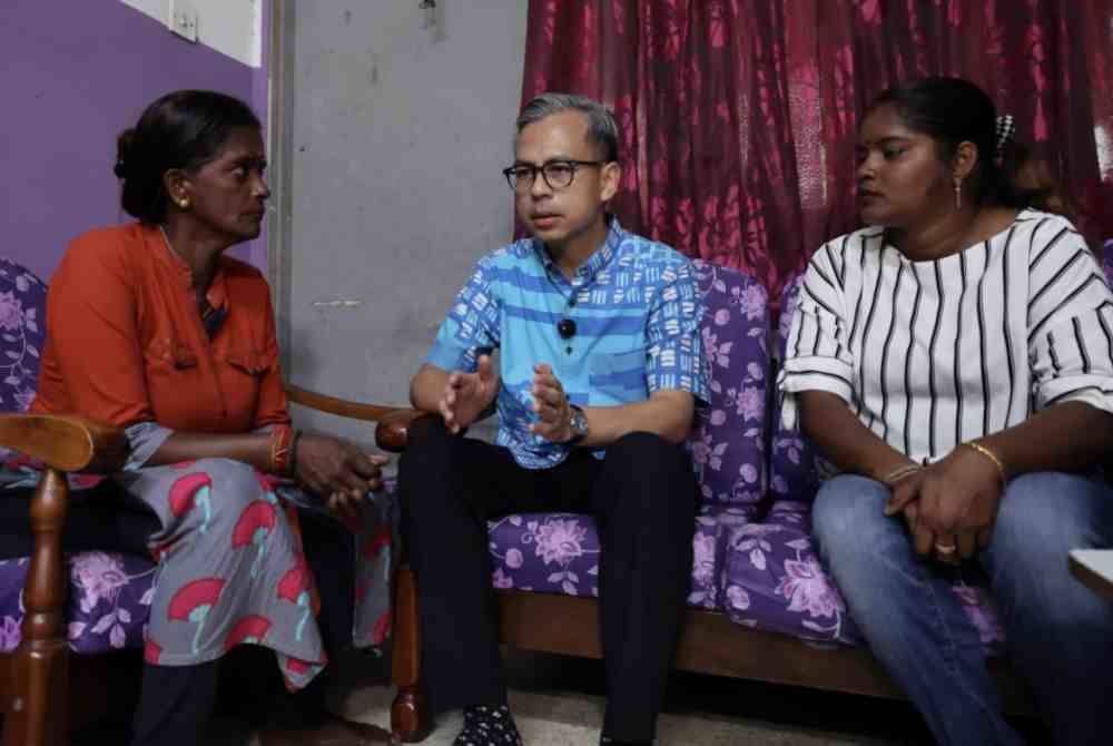 Fahmi ketika menyantuni PR Puspa (kiri) di kediamannya di Bandar Baru Ampang pada Ahad. Foto Bernama