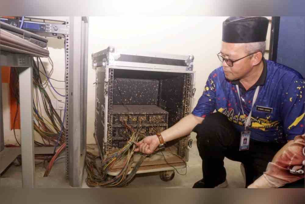 Ahmad Izham menunjukkan peralatan yang rosak selepas kejadian kepala air pada 18 Ogos 2021. Foto Bernama