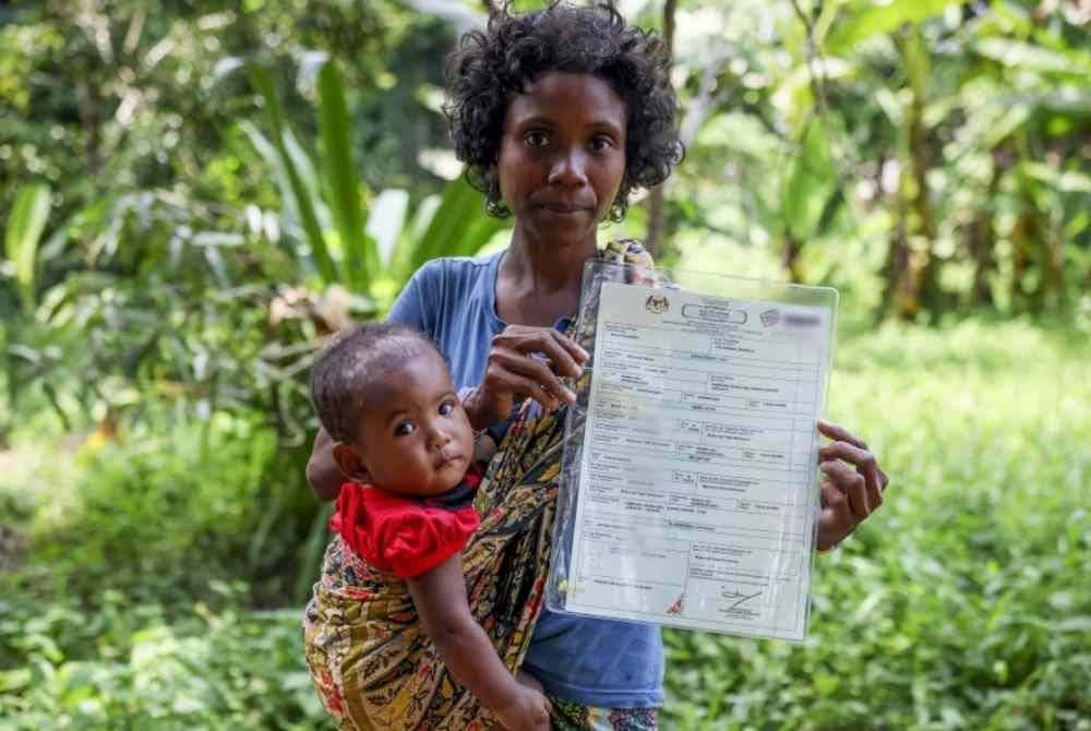 Bayi Orang Asli suku kaum Bateq, Shila Majid, empat bulan dan ibunya bersama sijil kelahiran yang diterima. Foto Bernama