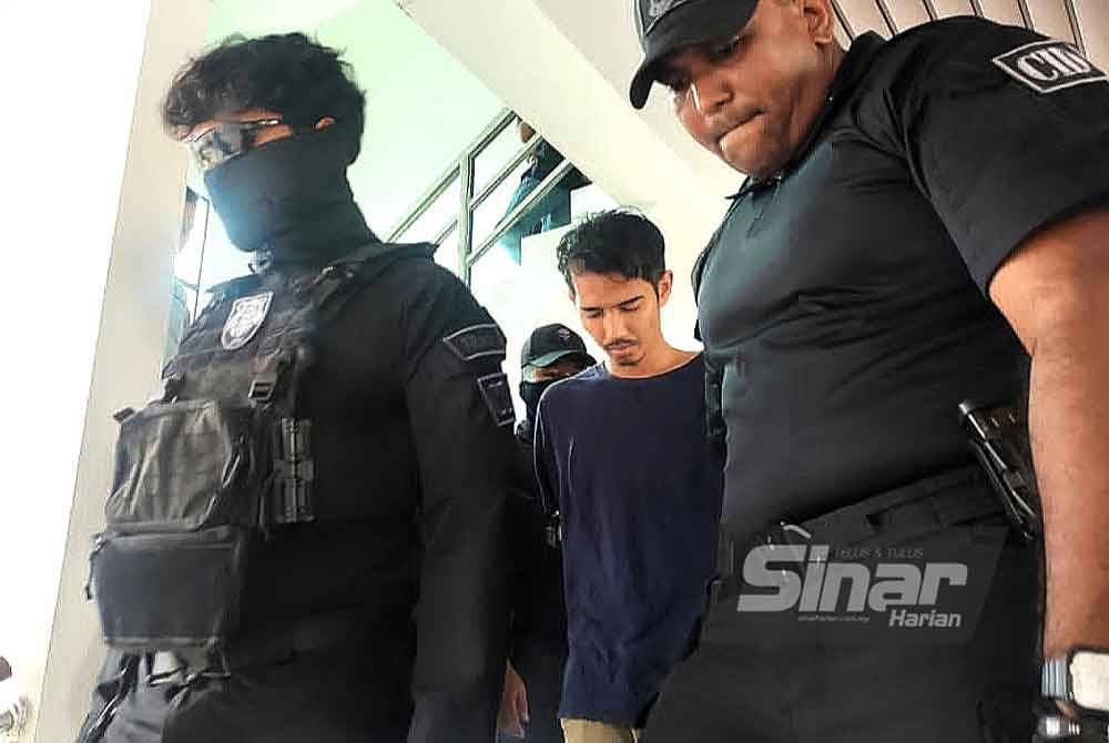Mohd Fadzly diiring polis ketika hadir ke mahkamah.